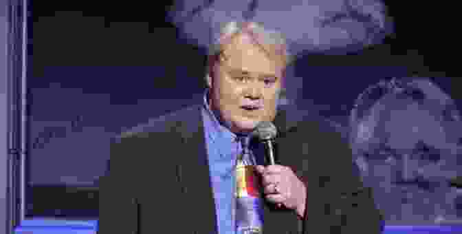 Louie Anderson Smiling And Holding A Microphone STARS WE VE LOST IN 2024: Remembering The Celebrities Who Died This Year